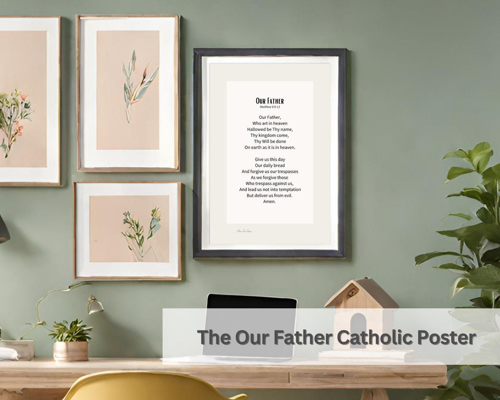 Framed artwork on a wall with a desk and chair, featuring 'The Our Father Catholic Poster'.